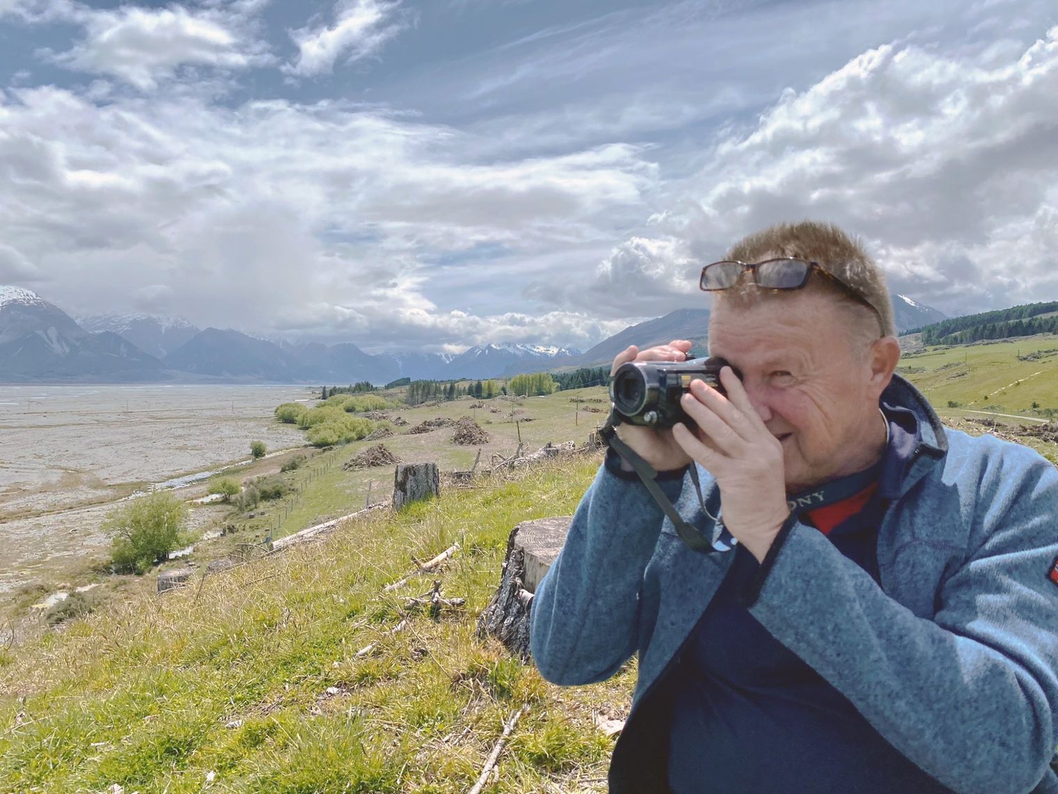 Iemand die met een camera een foto maakt van een landschap in de buitenlucht