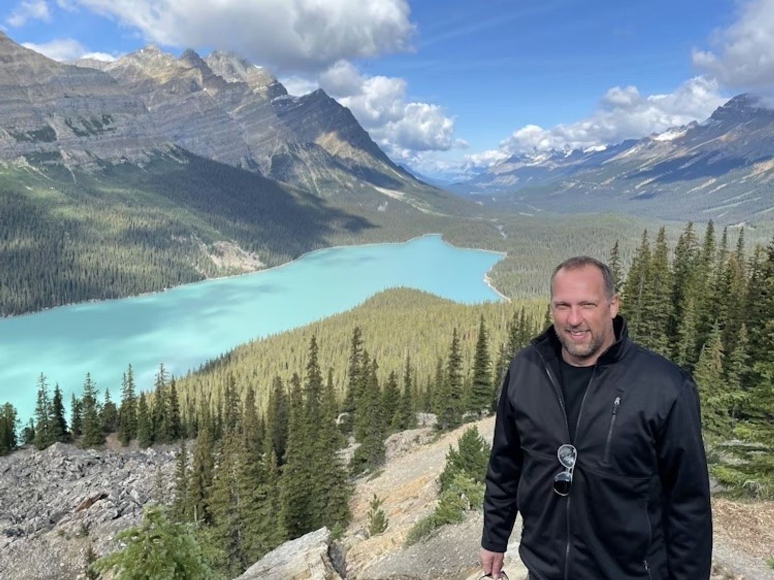Mann steht vor Bergen und See in Kanada