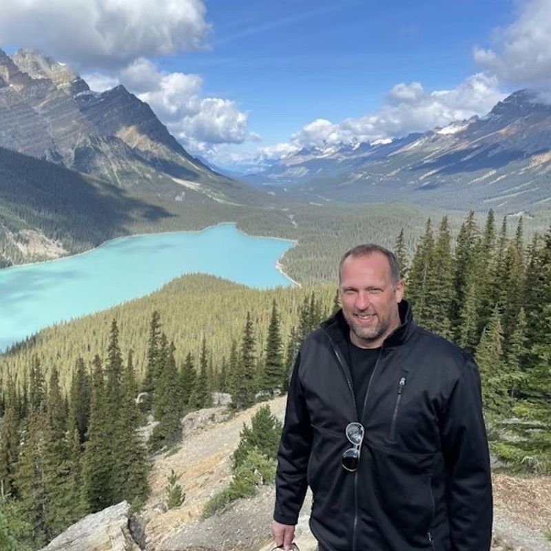 Mann steht vor Bergen und See in Kanada