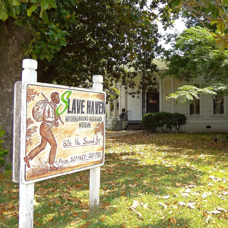 Een bord met daarop de tekst 'Slave Haven Underground Railroad Museum' voor een wit houten huis