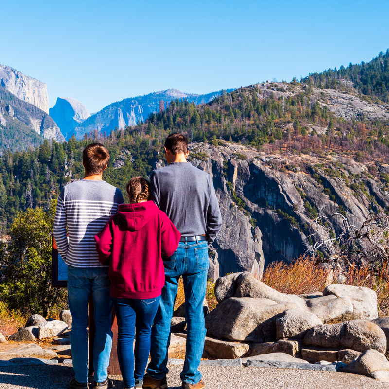 Family at a viewpoint looking over mountains of Yosemite National Park