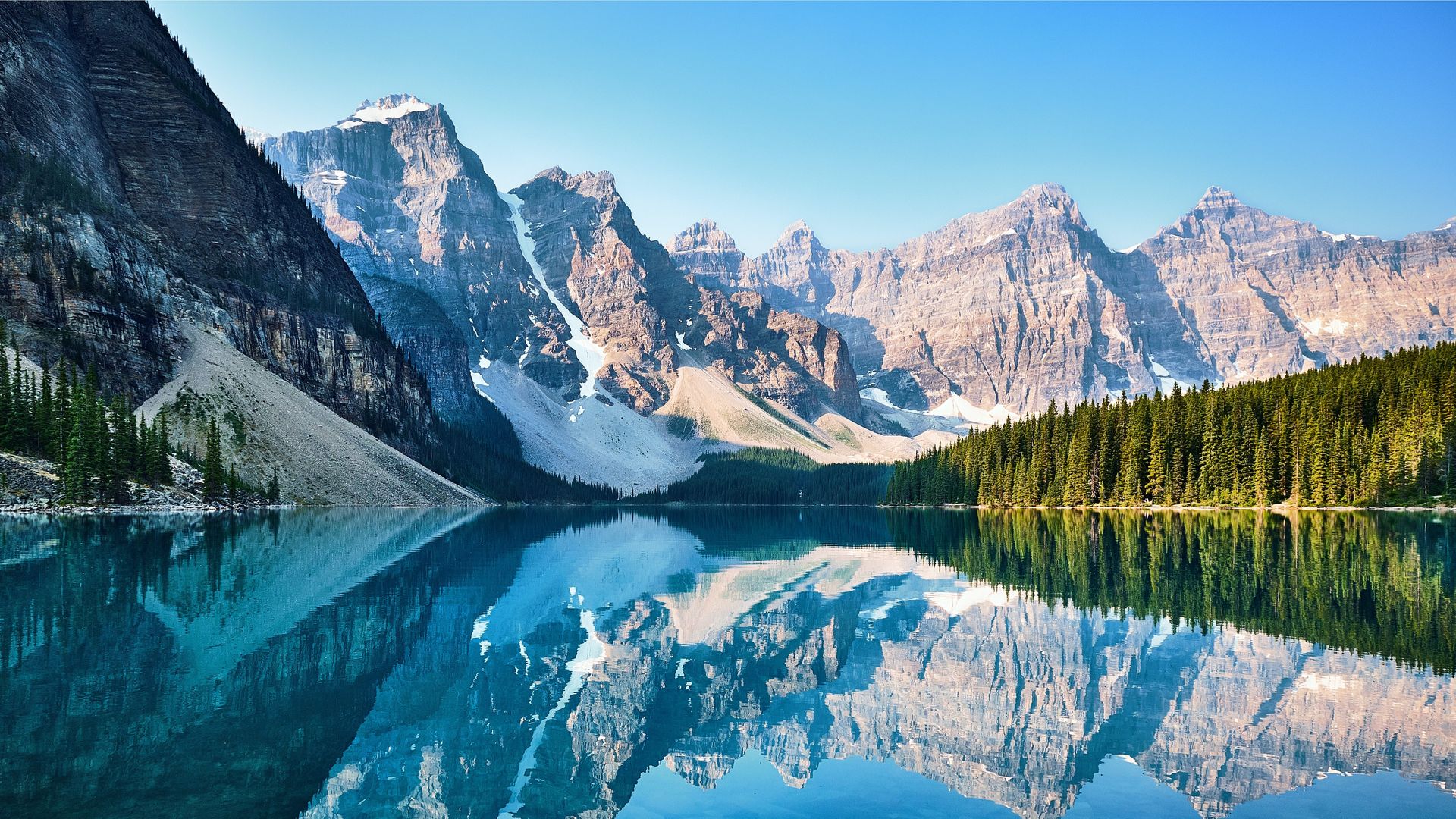 View over a lake, the forest meets the mountains range in the background
