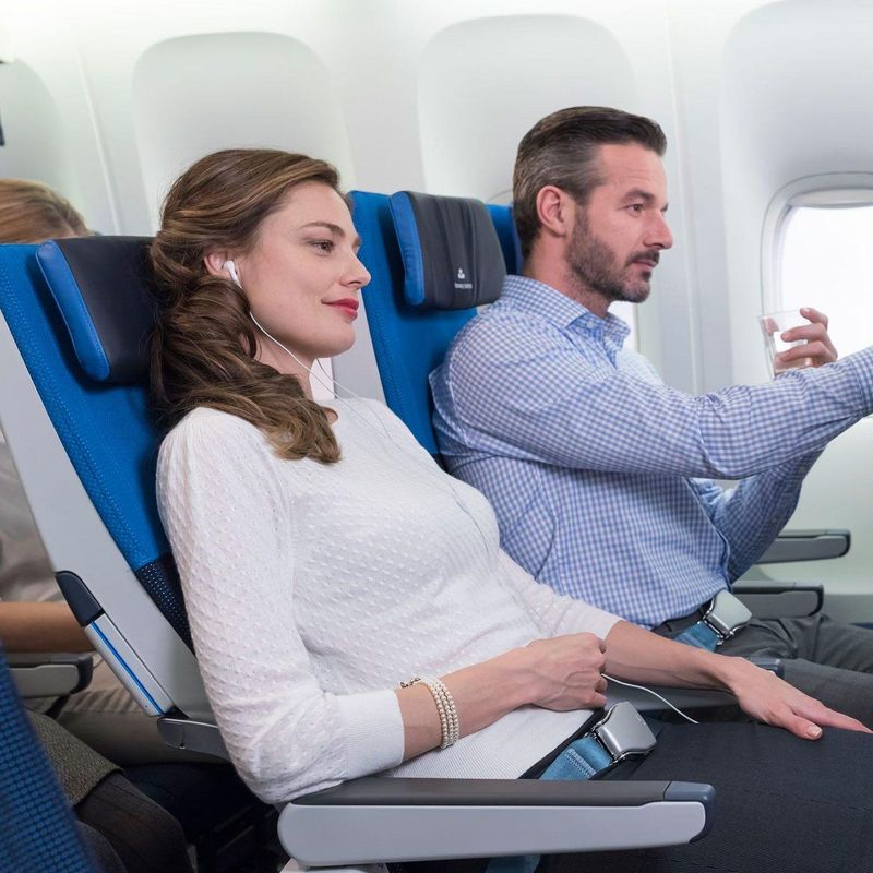 Zwei Personen fliegen in der Premium Economy, eine nutzt das Bordunterhaltungssystem