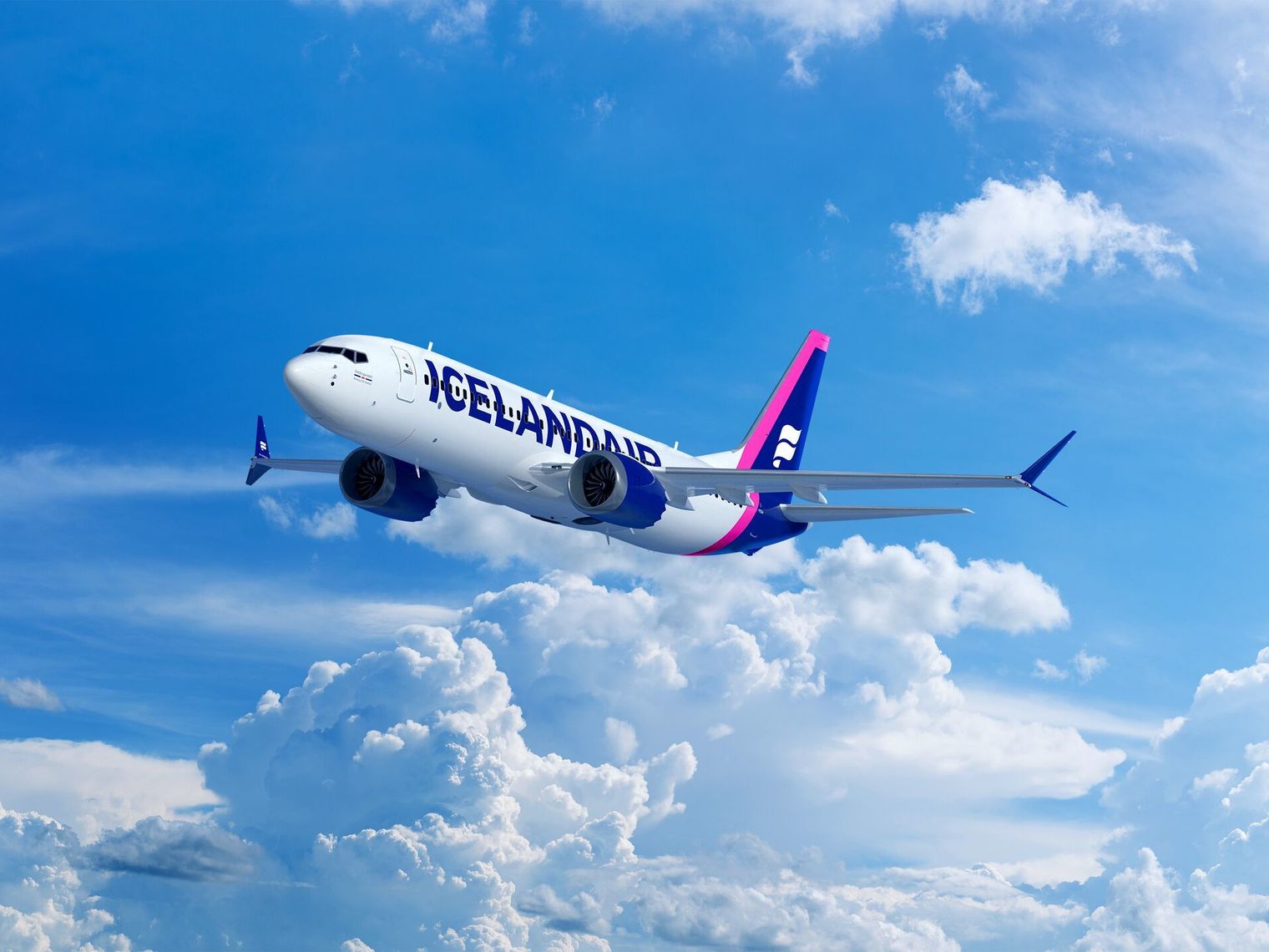 Ein Flugzeug der Icelandair fliegt über strahlend weißen Wolken vor einem klaren blauen Himmel.