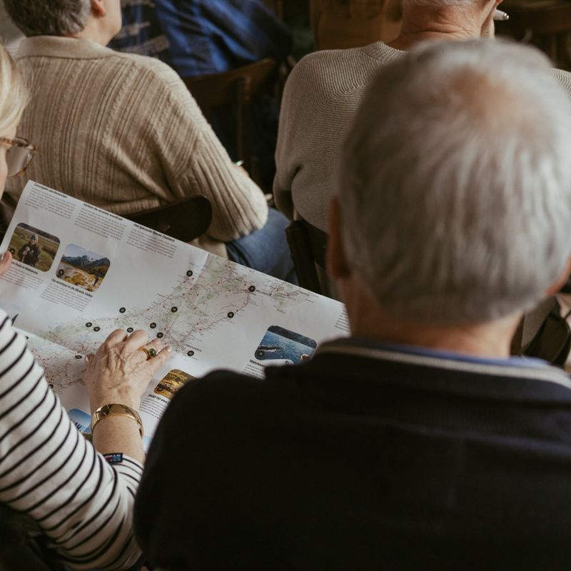 Two people read a TravelEssence brochure to plan their trip to New Zealand