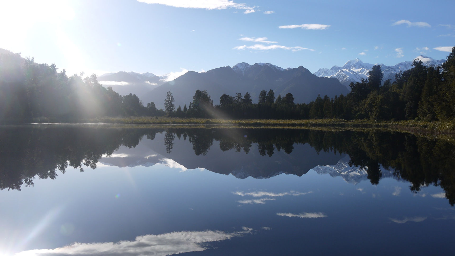 Spiegelbeeld van bergen en bos in Lake Matheson, Nieuw-Zeeland