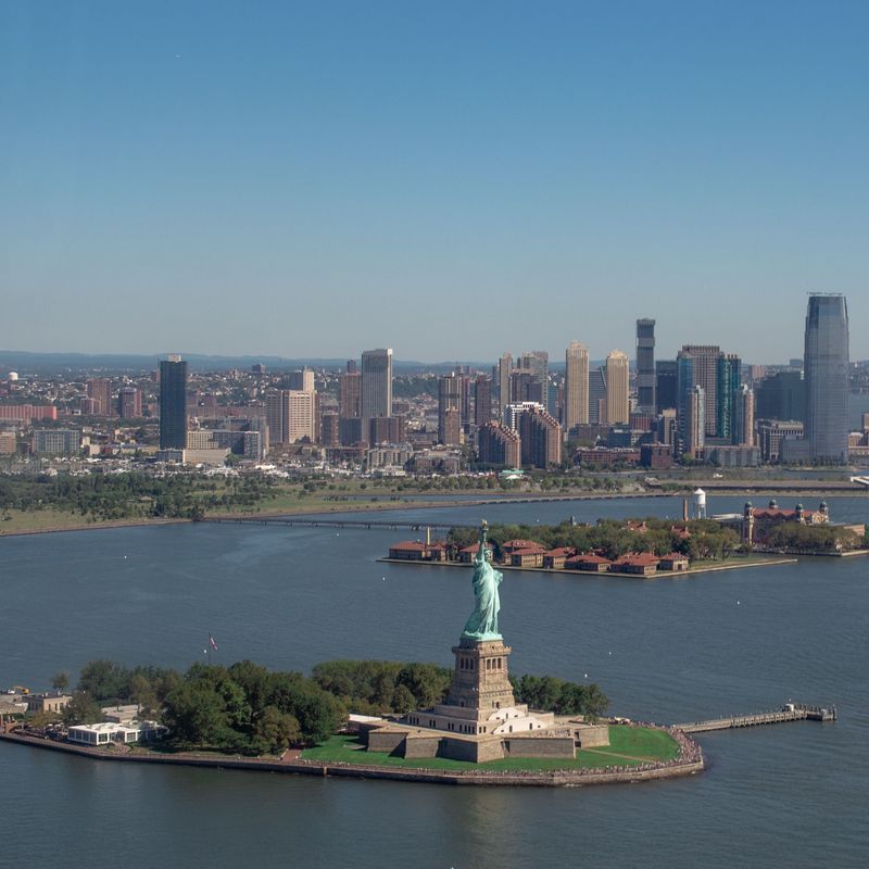 Uitzicht vanuit de lucht op de Statue of Liberty met wolkenkrabbers op de achtergrond
