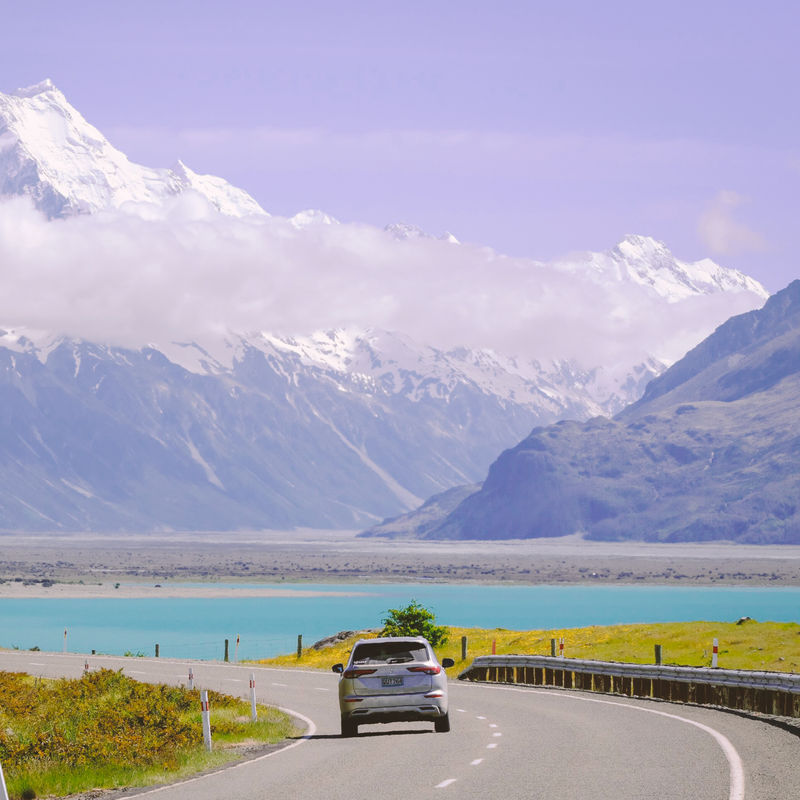 Een autorit over een schilderachtige weg langs het turquoise water van Lake Pukaki, richting de met sneeuw bedekte toppen van Aoraki Mount Cook, een autorondreis door Nieuw-Zeeland