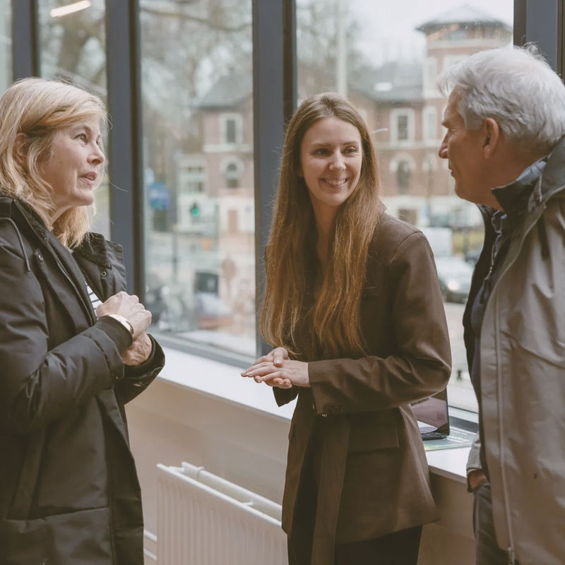 A sales specialist chats to two customers in front of a window