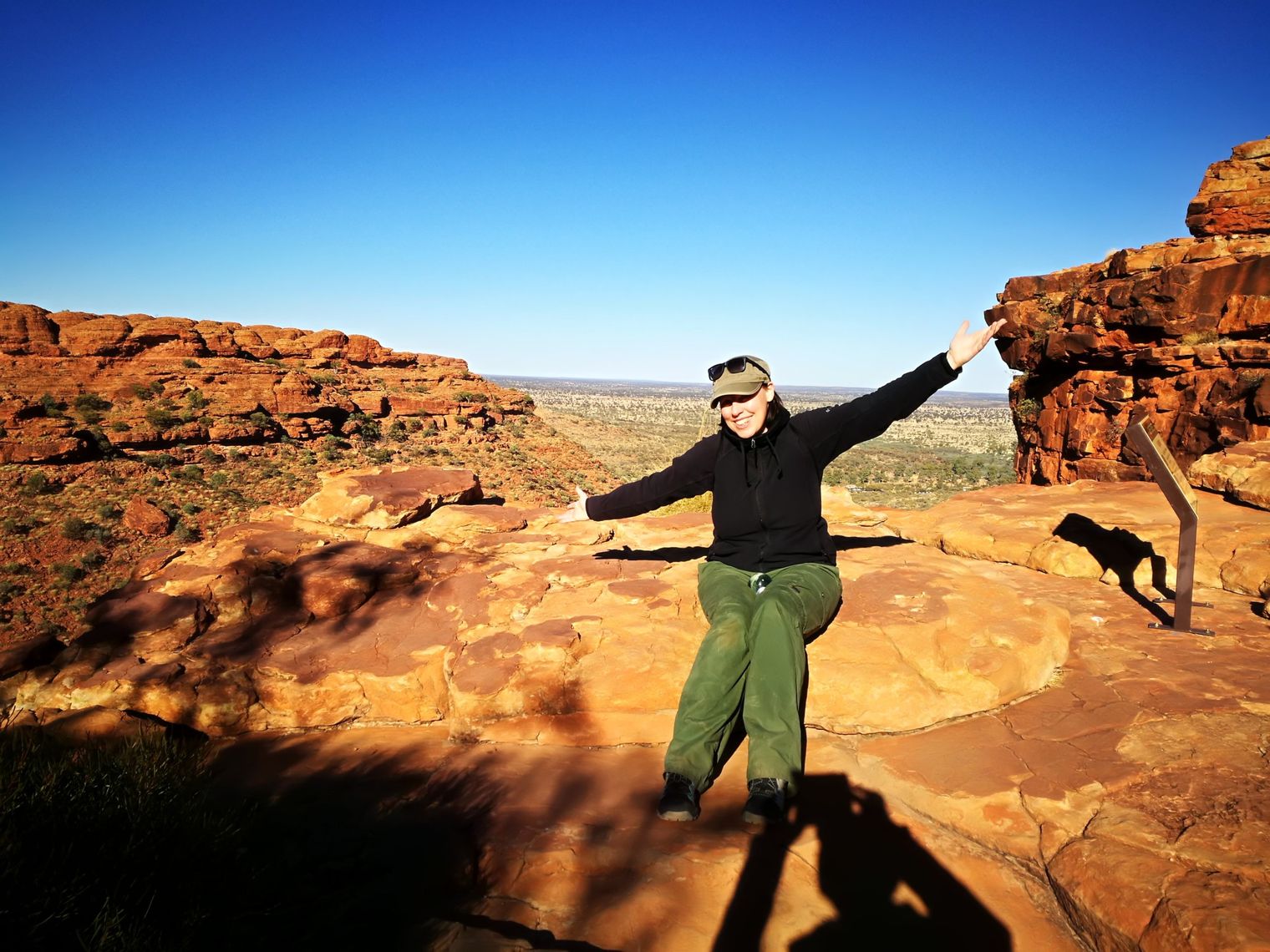 Nicole sitzt auf einem Felsen im Red Centre in Australien.