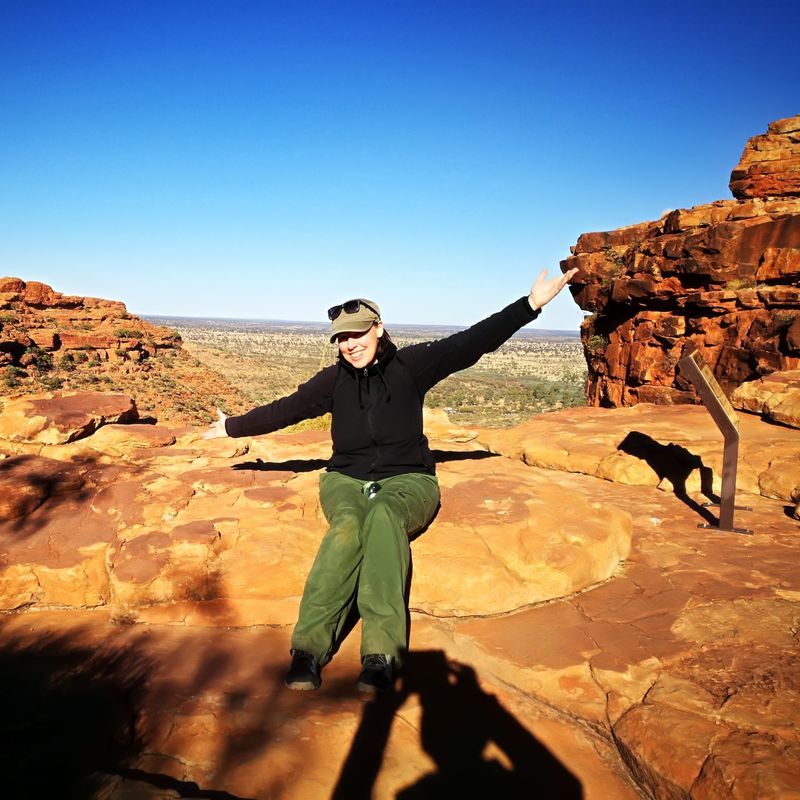 Nicole sitzt auf einem Felsen im Red Centre in Australien.