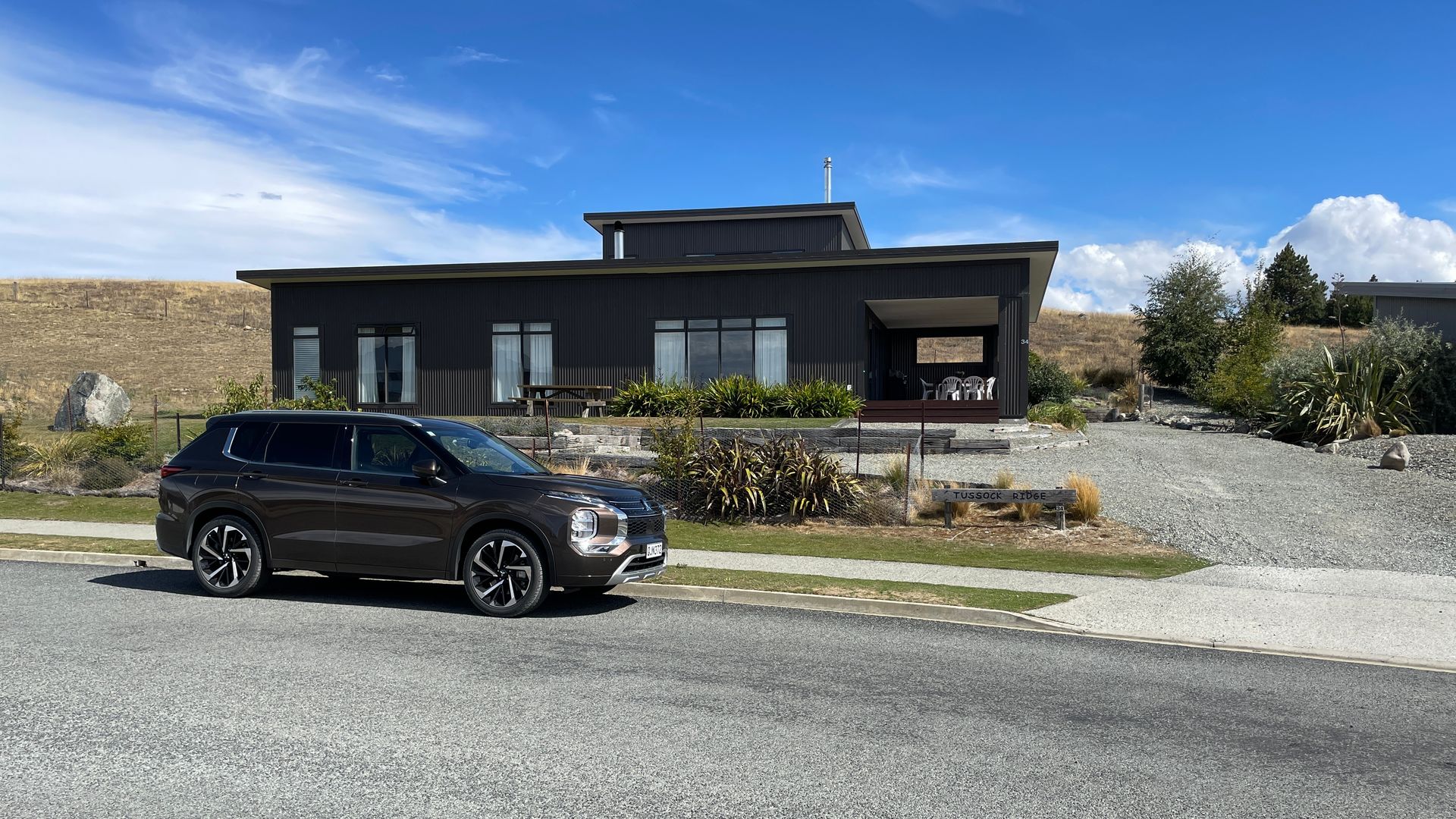 Mietwagen vor einem modernen Ferienhaus in Neuseeland