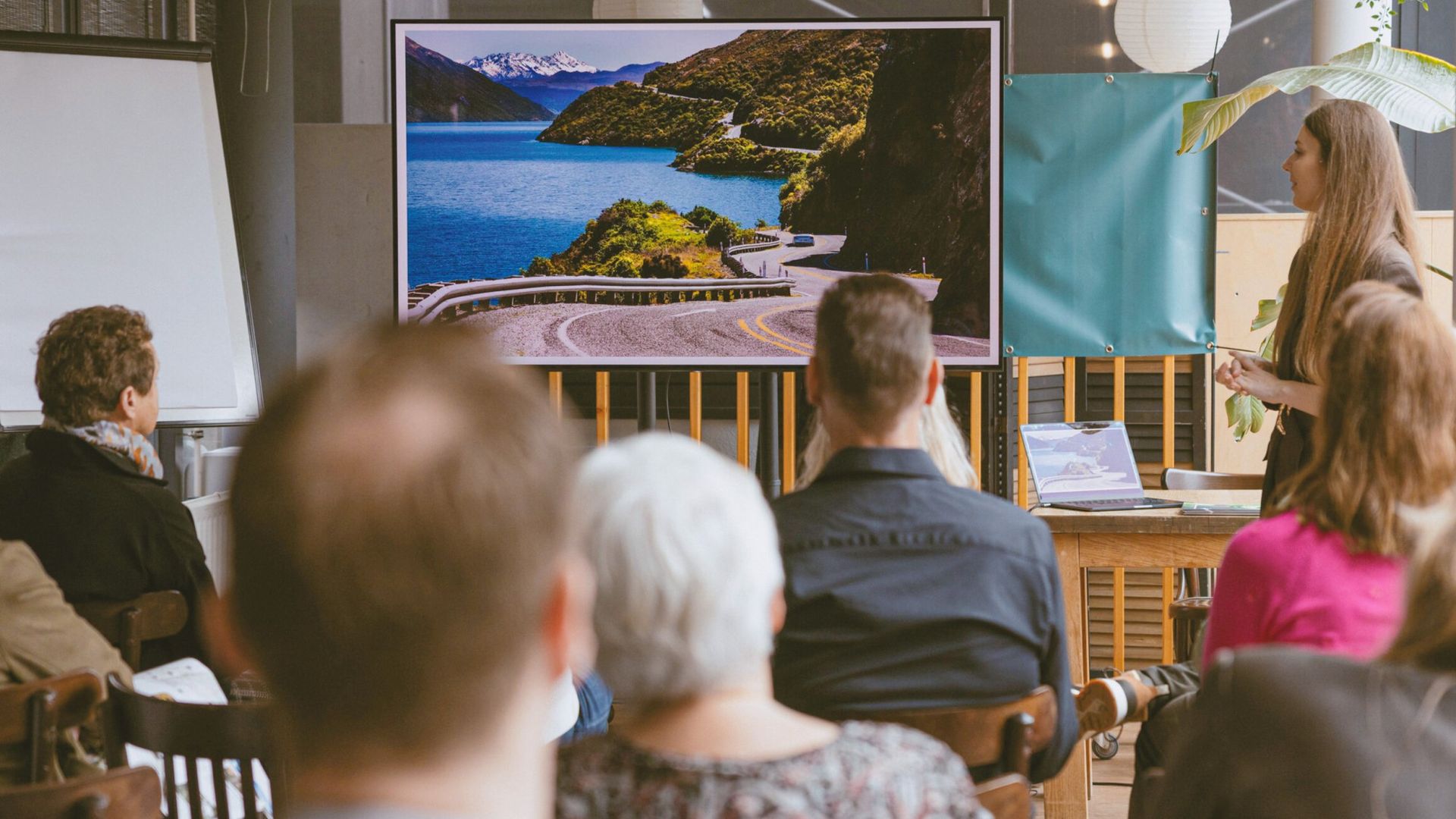 De reisexpert van TravelEssence geeft een presentatie over een land in een zaal vol mensen.