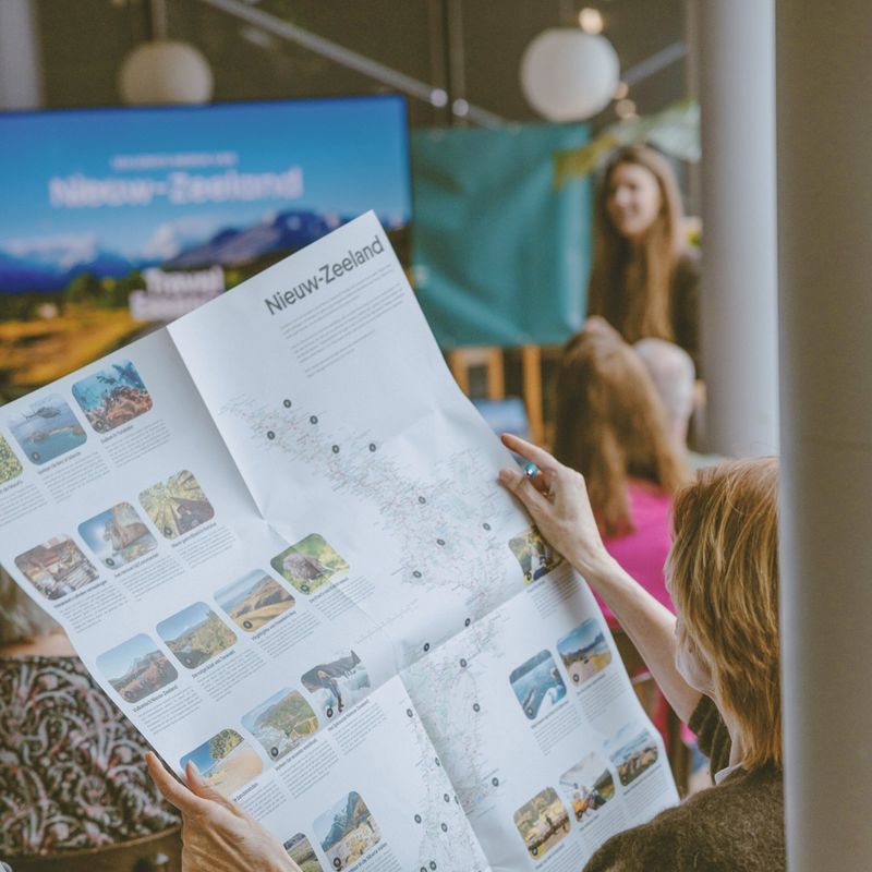 Een vrouw bekijkt een kaart van Nieuw-Zeeland tijdens een reispresentatie van TravelEssence.