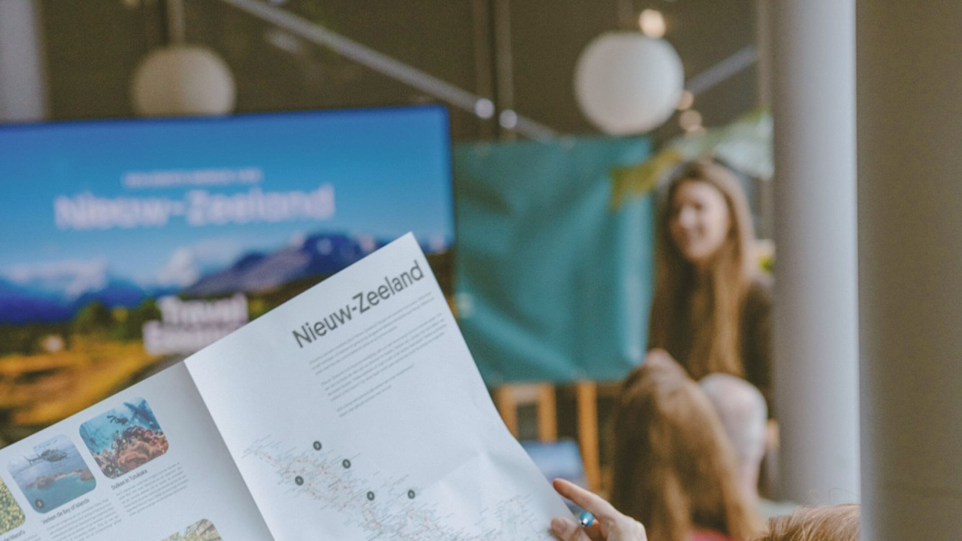 Een vrouw bekijkt een kaart van Nieuw-Zeeland tijdens een reispresentatie van TravelEssence.