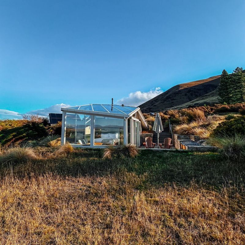 Skycape-hut met glazen dak voor sterrenkijken in het graslandschap bij Twizel, Nieuw-Zeeland