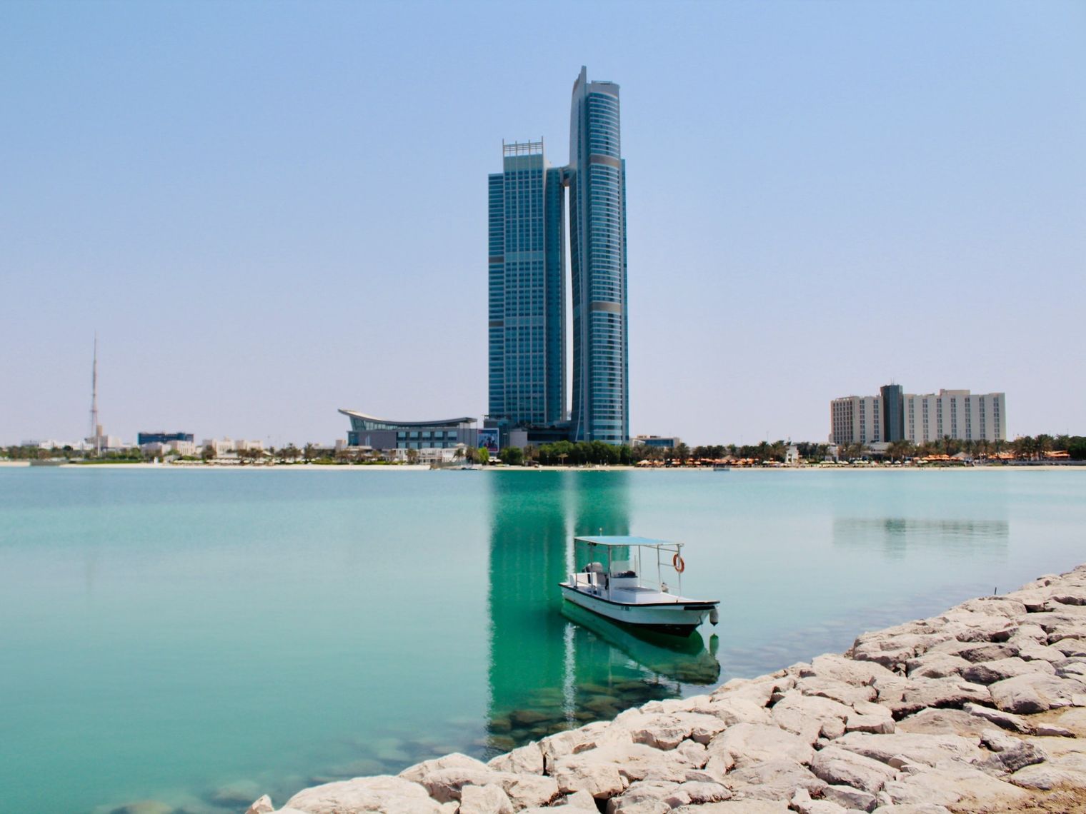 Bucht mit Boot mit Hochhaus im Hintergrund in Abu Dhabi