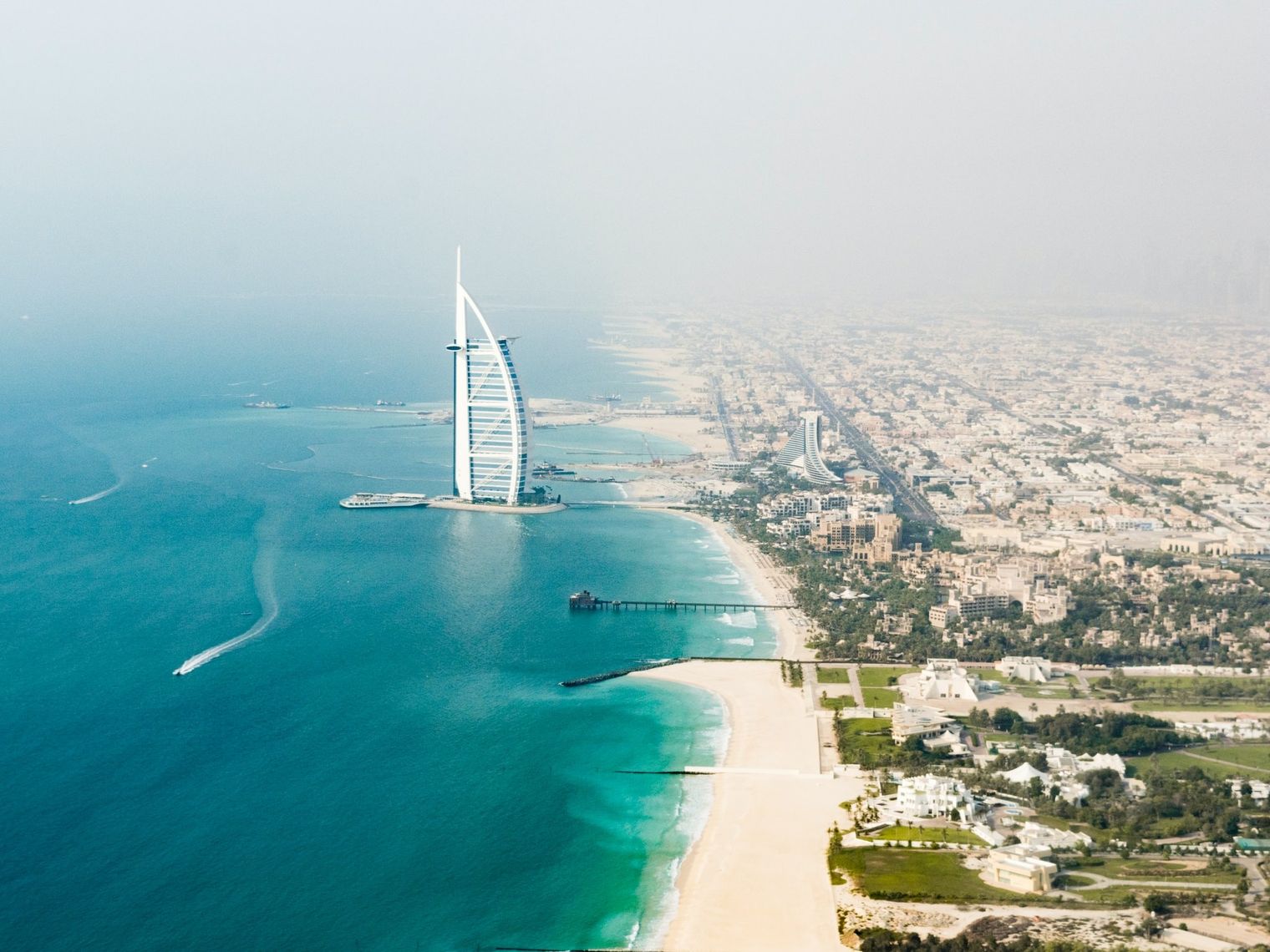 Turm Bujj Al Arab im Wasser mit Küste von Dubai