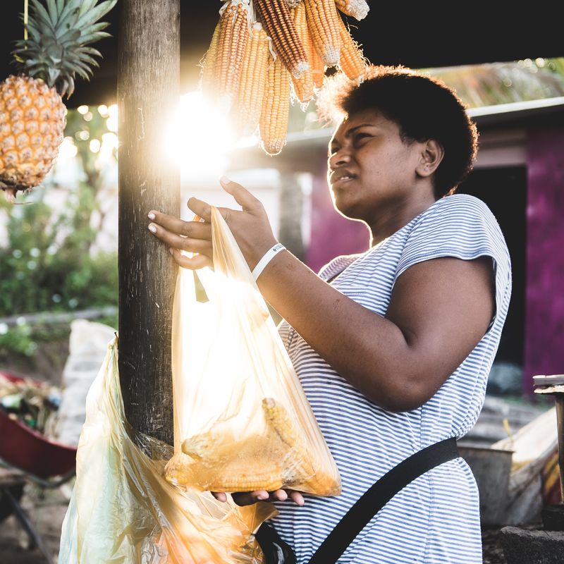 Een vrouw met ananas en maïs
