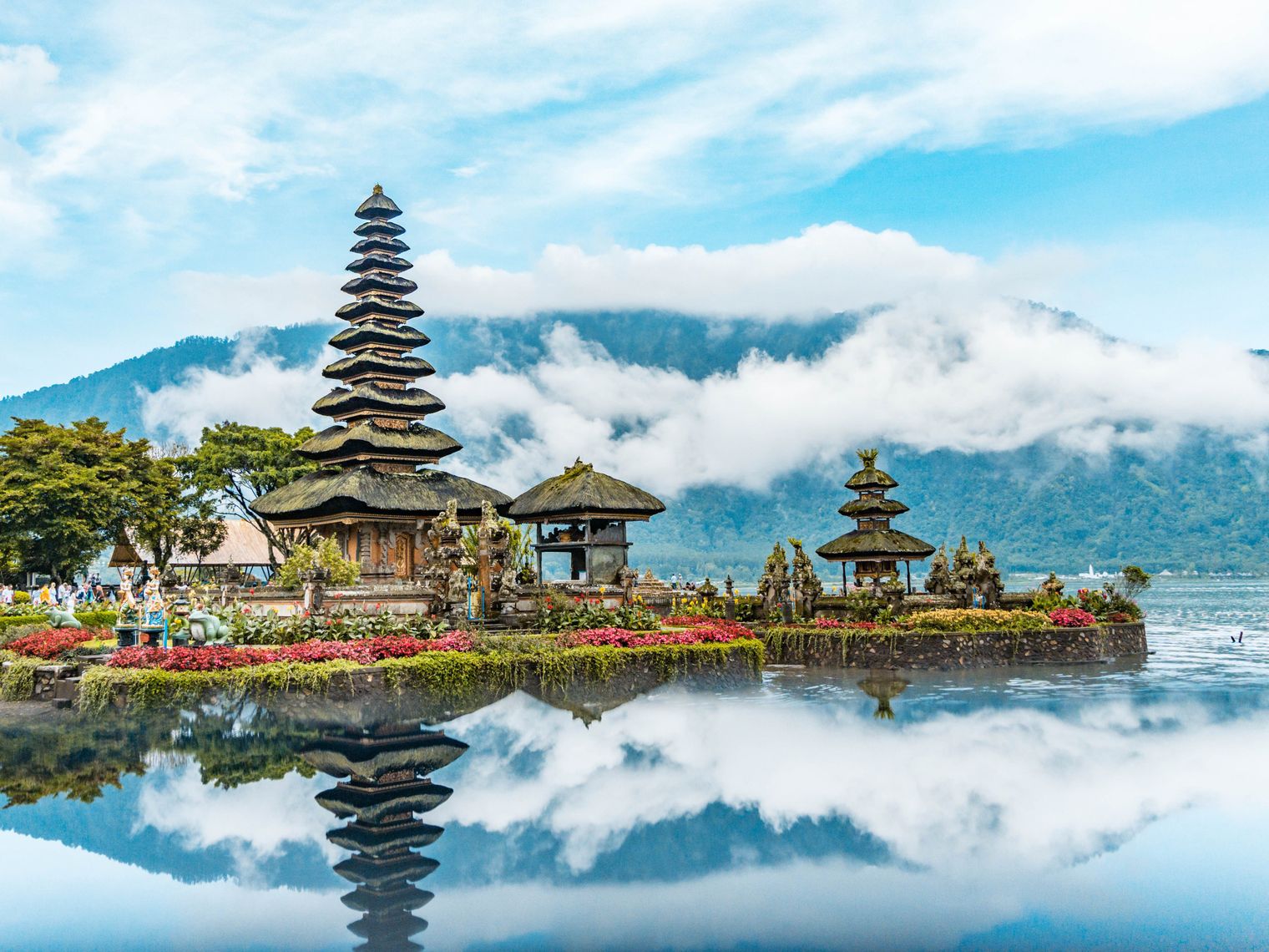 Tempel auf Bali, die sich in Wasser spiegeln mit Bergen im Hintergrund