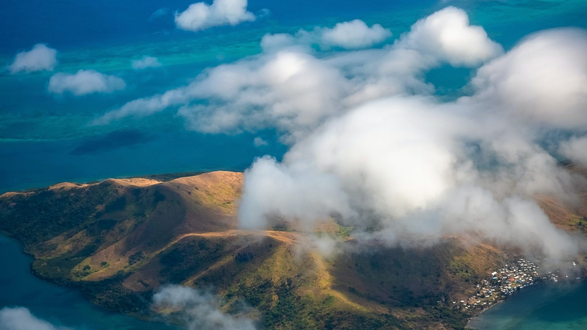 Luftaufnahme einer Insel durch die Wolken