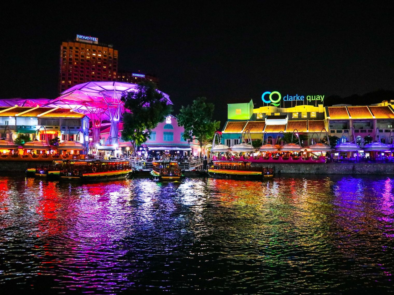Fluss bei Nacht mit bunt leuchtender Promenade