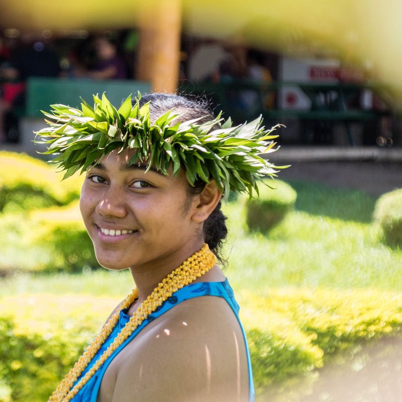 Een vrouw glimlacht naar de camera in een traditionele outfit