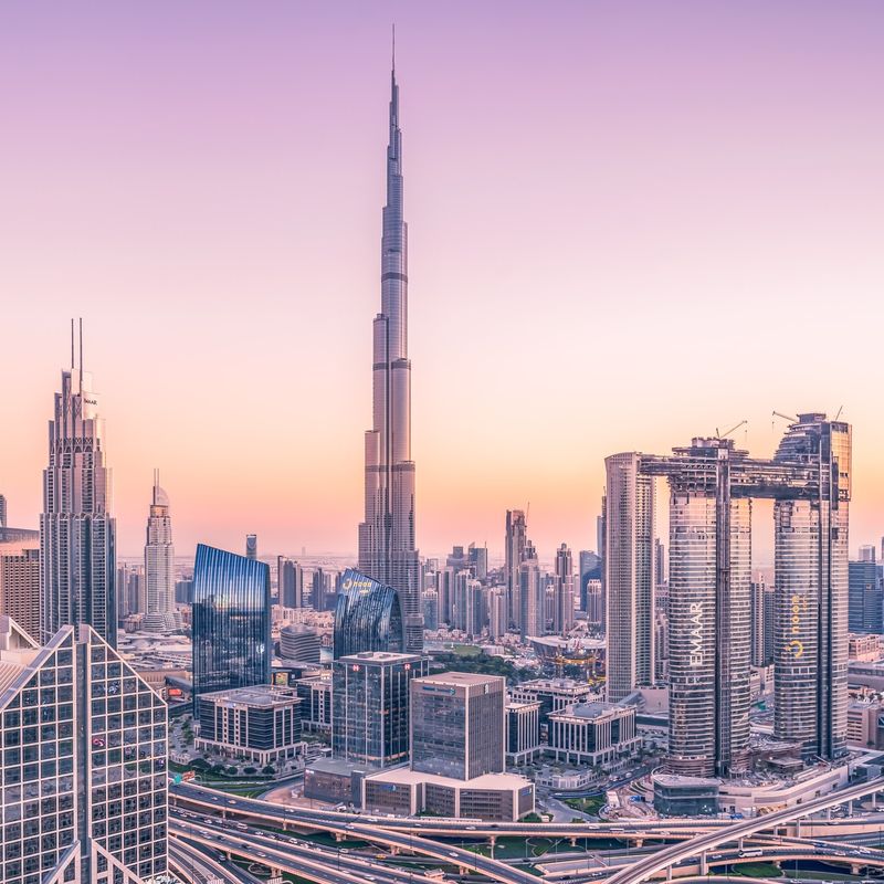 Blick auf Hochhäuser bei lila Sonnenuntergang in Dubai