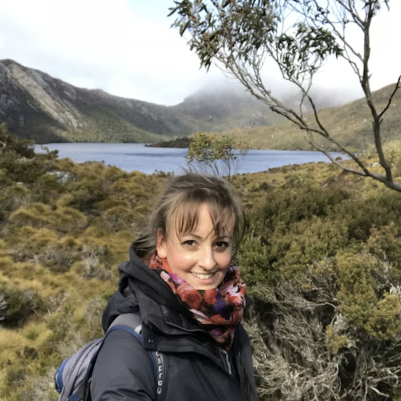 Junge Frau steht vor See und Bergen in Neuseeland