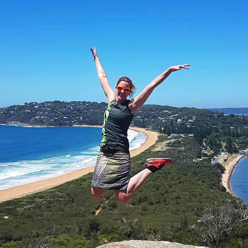 Melanie Springen Pose für die Kamera vor der Palme Strand, Australien