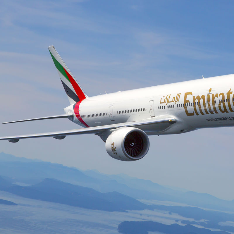Emirates plane flying against a blue sky
