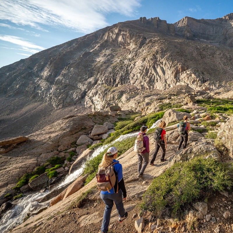 Eine Gruppe Wanderer läuft entlang schroffer Felsen in den Rocky Mountains bei Estes Park, USA