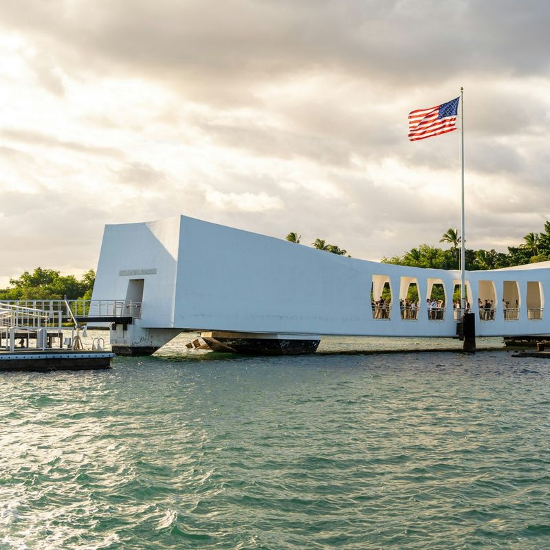 Een wit gebouw op het water, het museum en herdenkingsplaats de USS Arizona Memorial op Hawaii