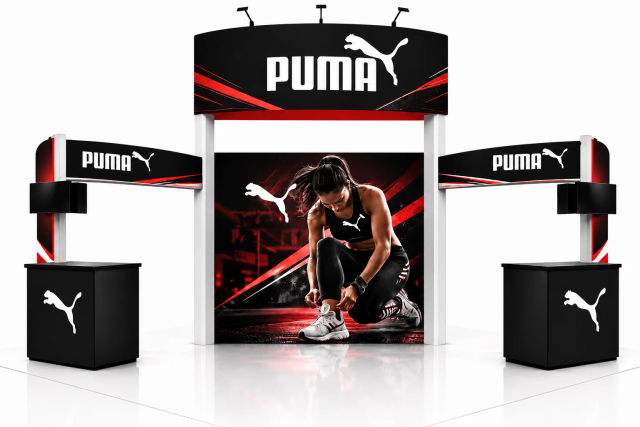 Custom 20x20 trade show booth design with an overhead sign, graphic center wall and two counters