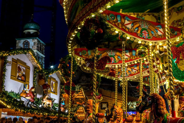 A carousel in a Christmas market at night.