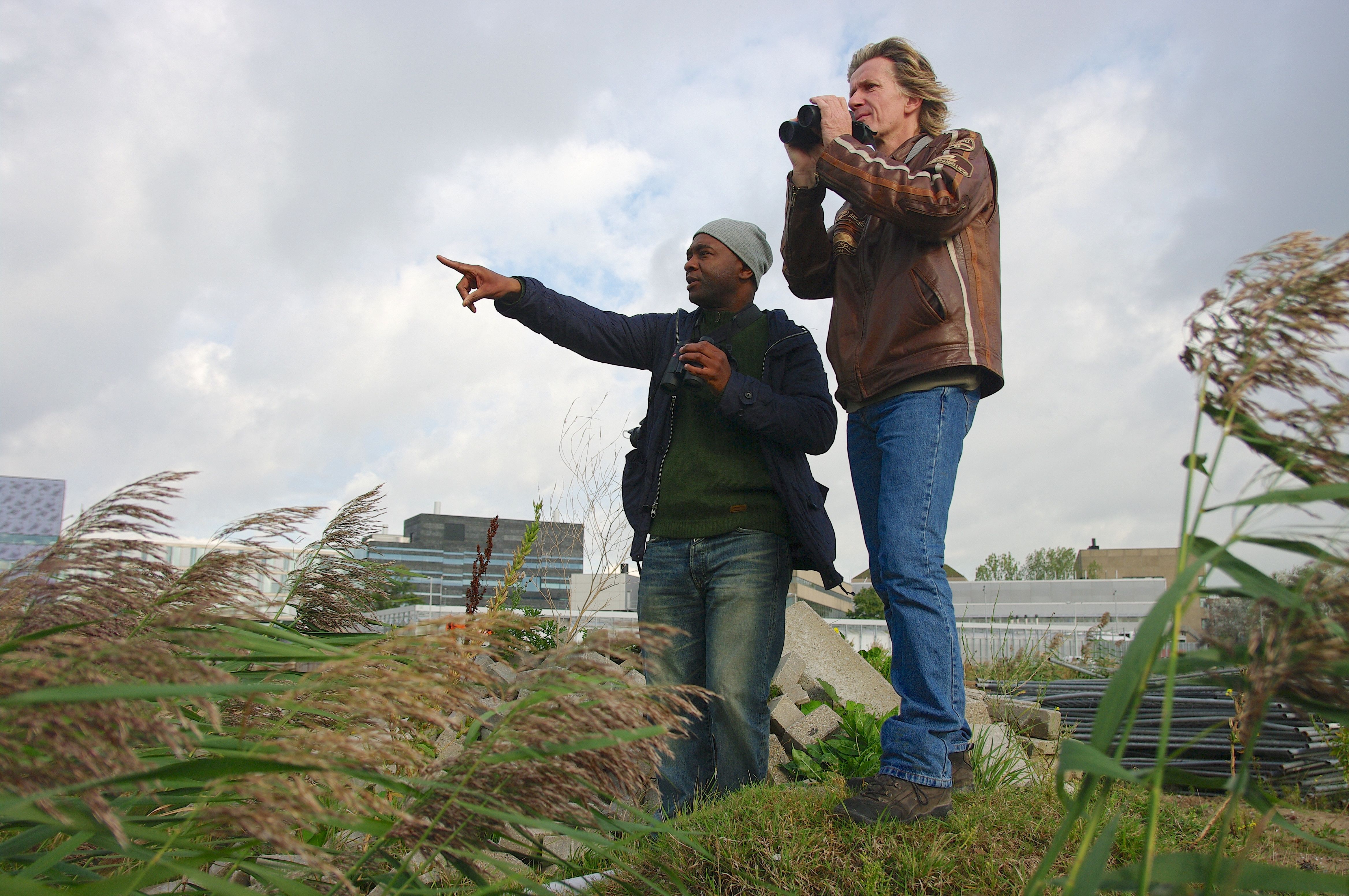 Two men standing on a rooftop.