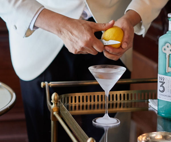 A man pouring a martini into a glass.