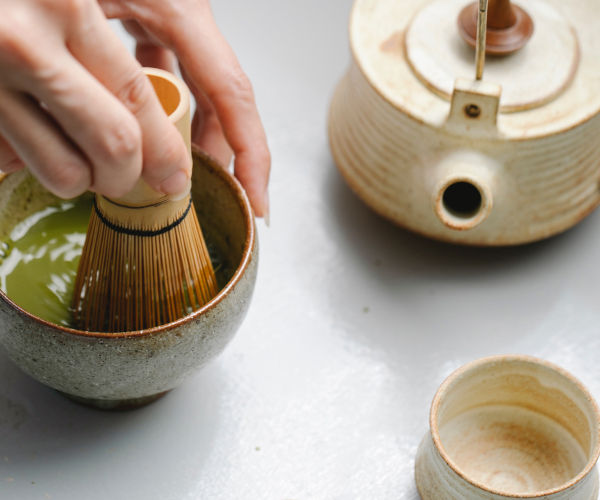 A person pouring tea into a bowl.