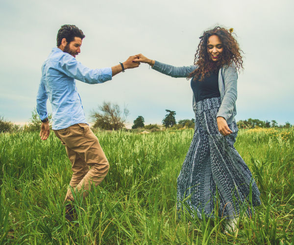 A man and woman are dancing in a field.