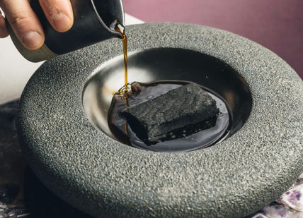 An image of someone pouring a liquid into a stone, Nine-course tasting menu at the Chef’s Table. Amethyst