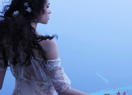 An image of a woman standing on a cliff, Personal Ayurvedic Programme. Ananda in the Himalayas