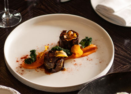 An image of a dish and glass of wine at Aqua Nueva