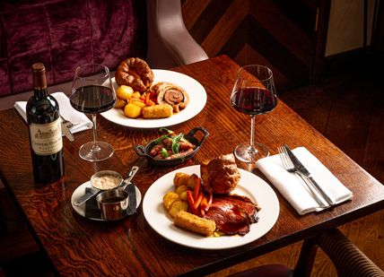 Am image of a table with a dish and glasses of wine