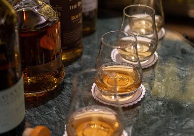 An image of a table with alcohol and glasses, Premium Whisky Masterclass. The Bar At The Athenaeum