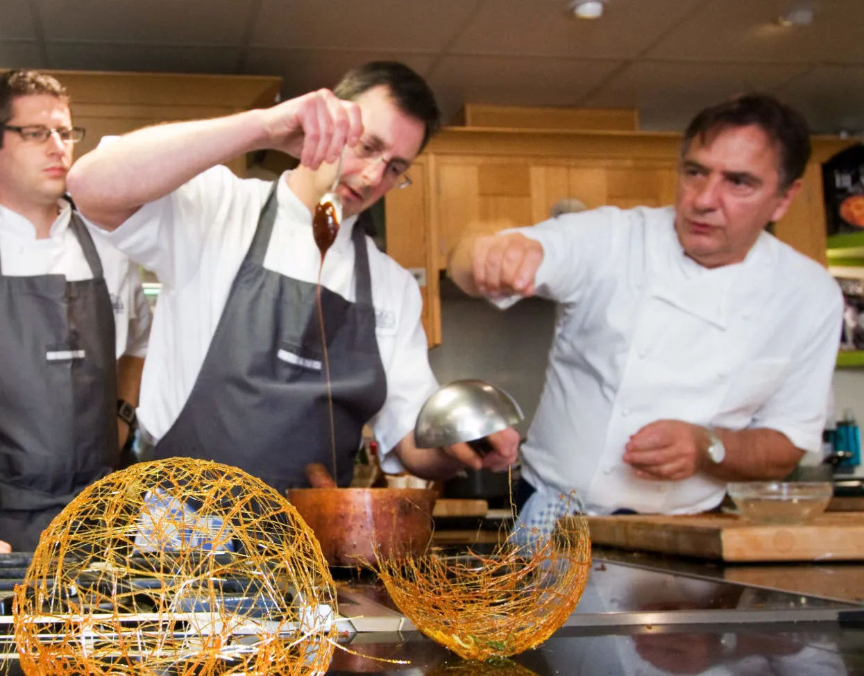 A group of chefs preparing food in a kitchen