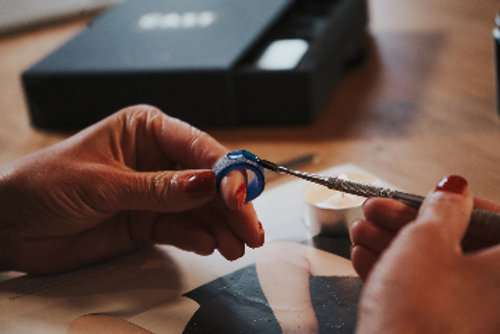 A woman is putting a ring on her finger.