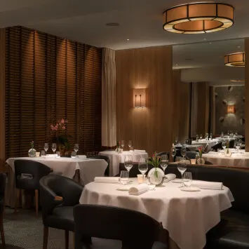 A dining room with black tables and chairs.