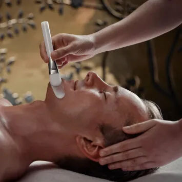 A man is getting his face massaged.