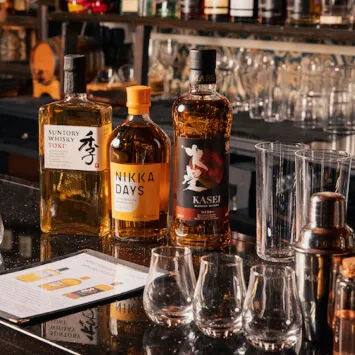 A bar full of whisky bottles and glasses.