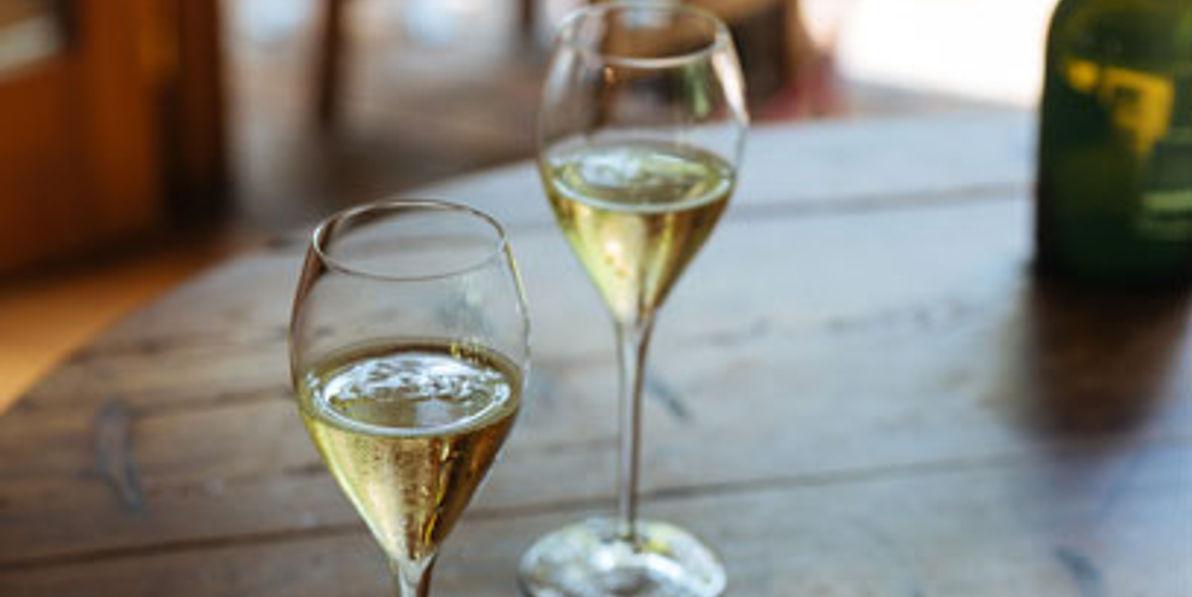 Two glasses of champagne on a wooden table.